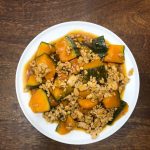 A white plate with kabocha squash and meat on it.