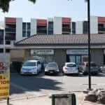 A parking lot with cars parked in front of a building.