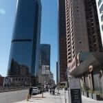 A city street with tall buildings in the background.