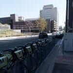 A row of bicycles parked on the side of a street.