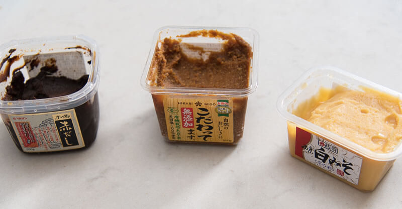 Different types of miso paste in tubs.