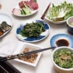 Japanese food on a table with chopsticks and bowls.