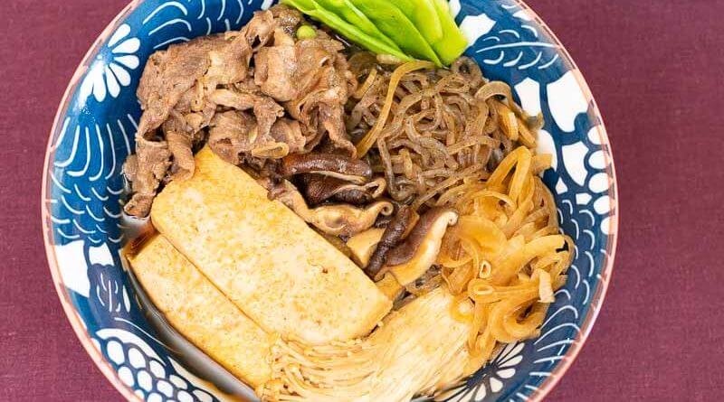 A bowl of tonkotsu ramen with shirataki noodles, beef, and vegetables.