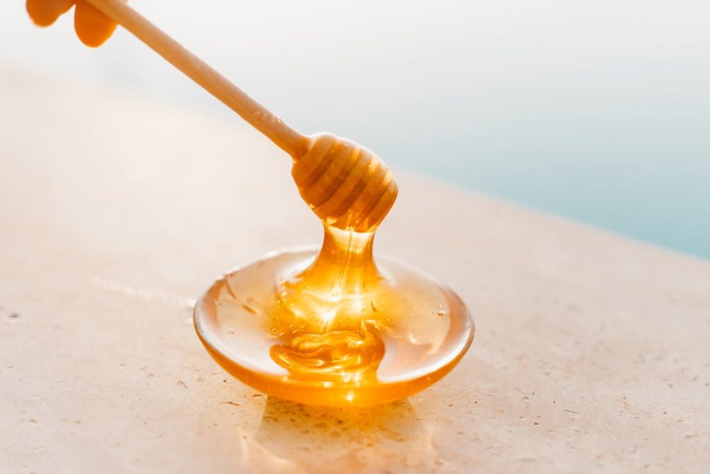 A person is pouring matcha syrup into a bowl.