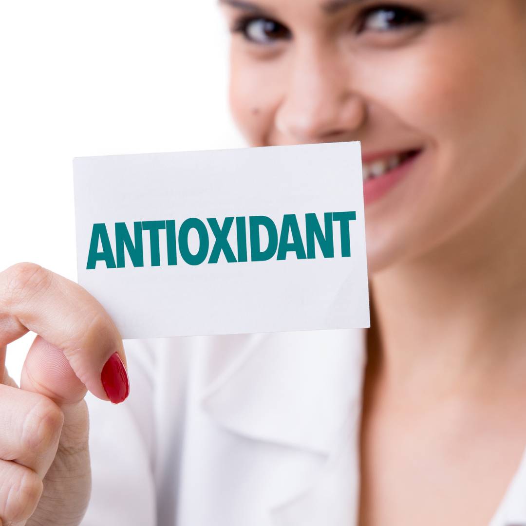 A woman holding a paper with antioxidant word