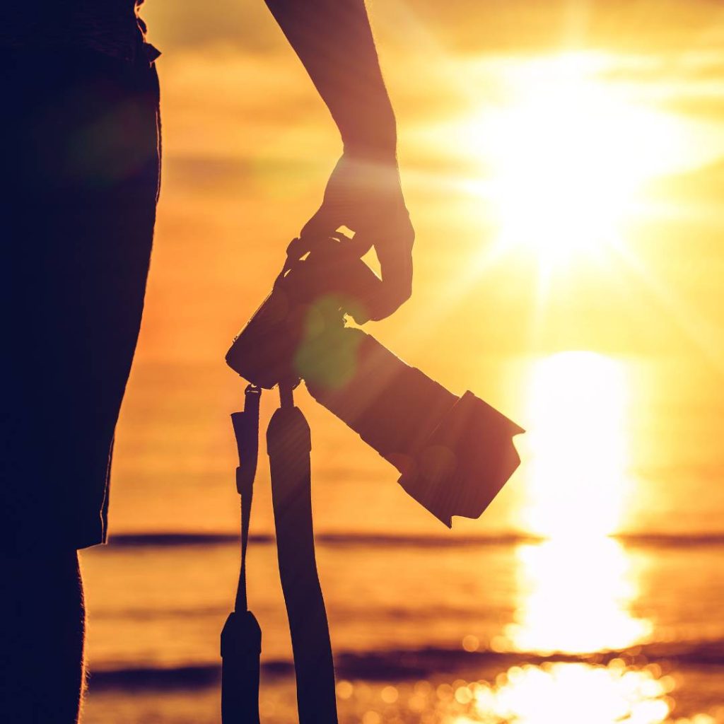 sunset photography with man holding a camera