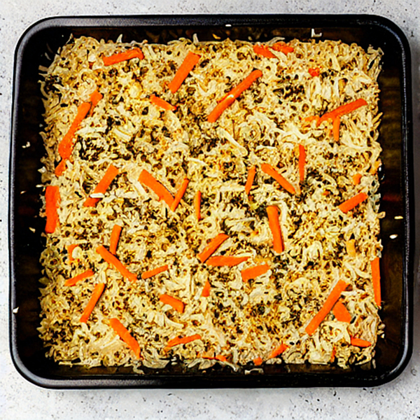 A tray with sushi bake containing carrots and rice.