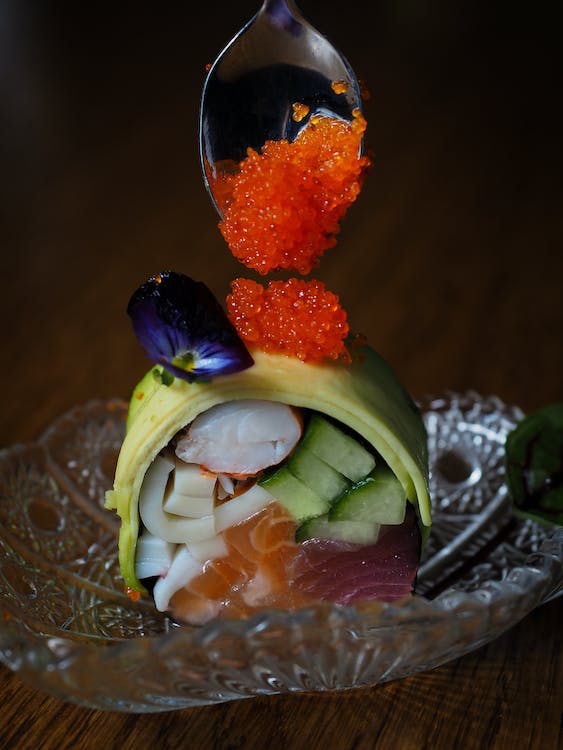 Roe in Sushi on a glass plate with a spoon.