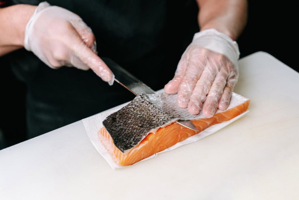 A person is slicing a Sushi Grade Fish on a cutting board.