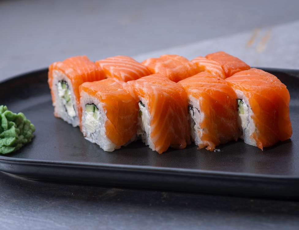 Fresh sushi grade salmon served on a sleek black plate.