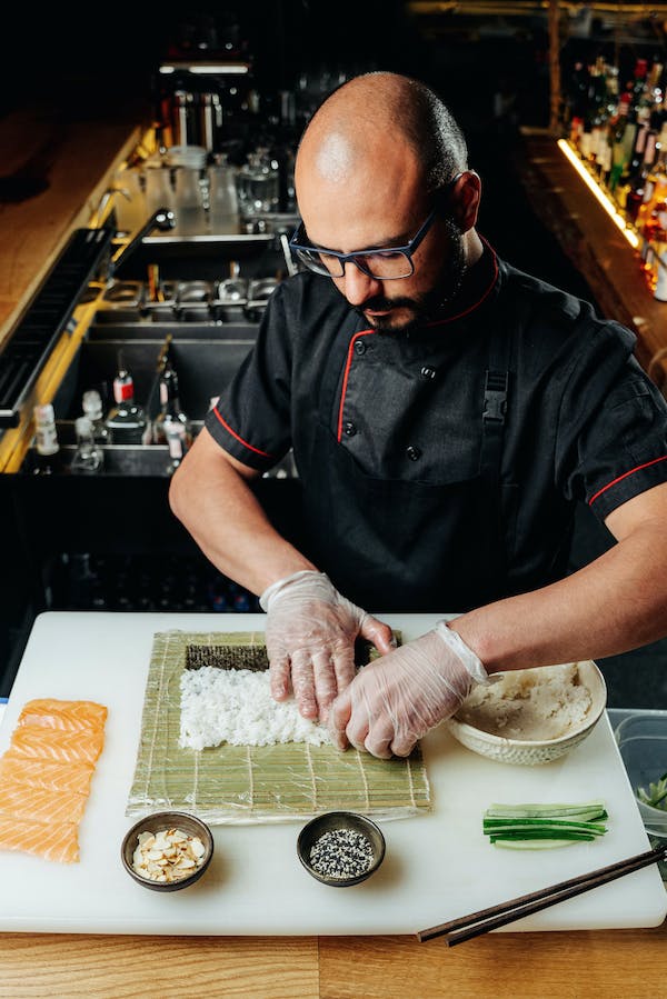 A chef tastefully preparing sushi on a cutting board.