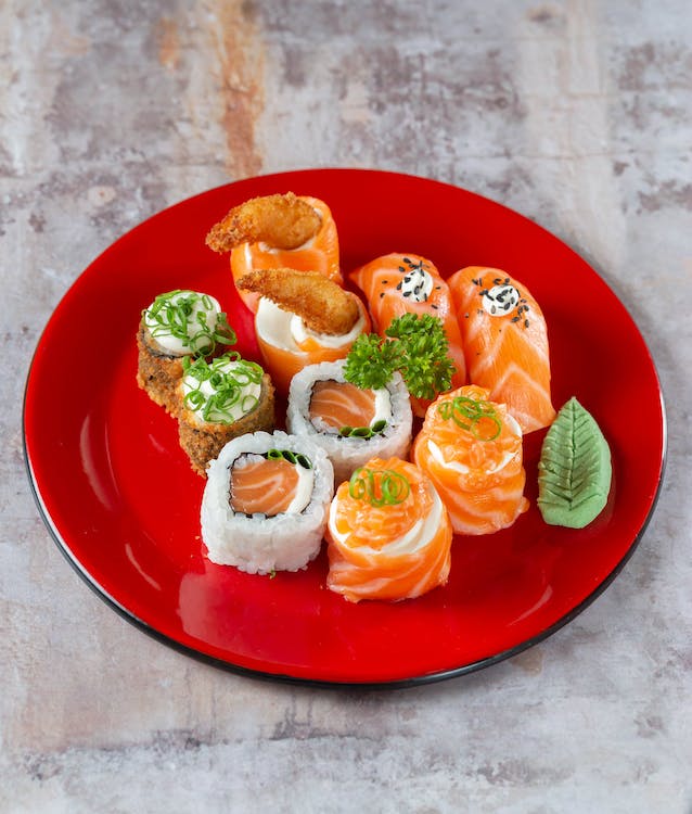 Japanese sushi served without a mat on a red plate.