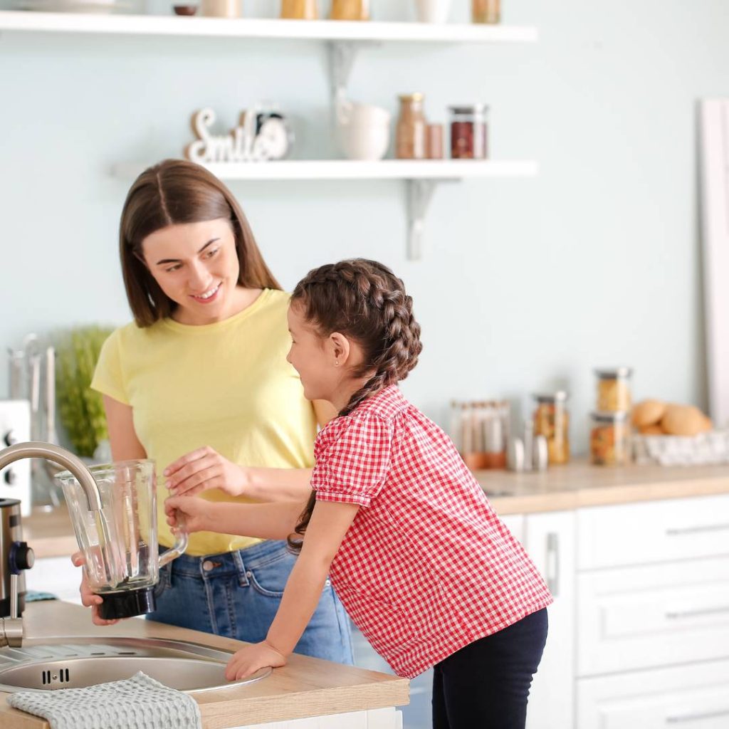 mom and daughter washing blender 