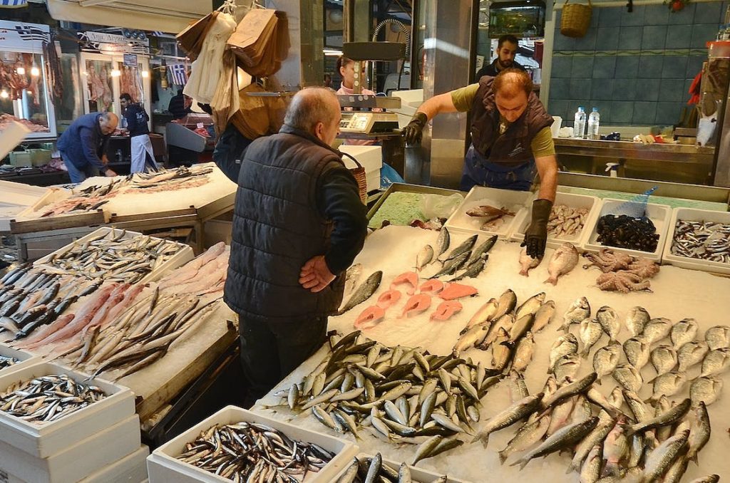 A fish market with a lot of sushi-grade salmon on display.