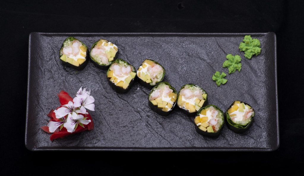 Japanese sushi rolls on a black plate, bursting with captivating sushi taste.