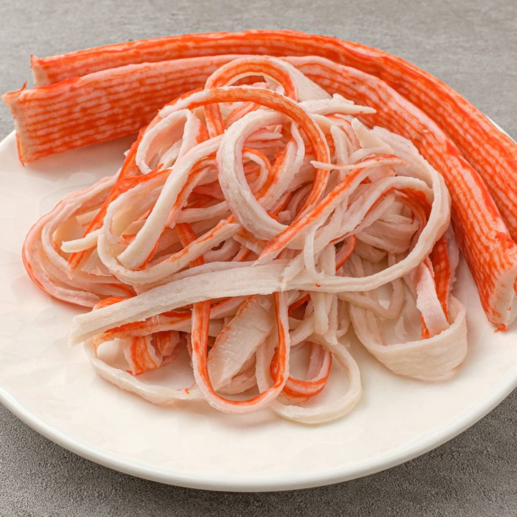 A white plate with a portion of imitation crab meat