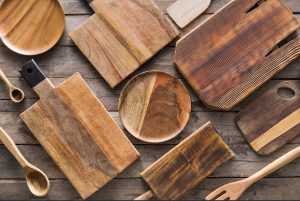 Various strongest cutting boards and utensils on a wooden table.