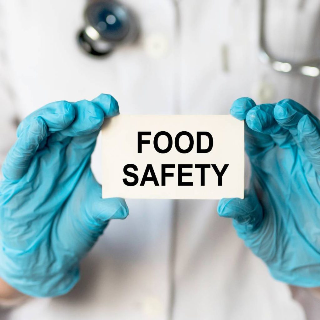 A doctor displaying a sign with keywords "food safety" and "Is All Sushi Raw".