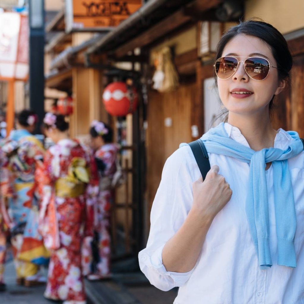 A woman in a kimono and sunglasses exploring Kyoto.