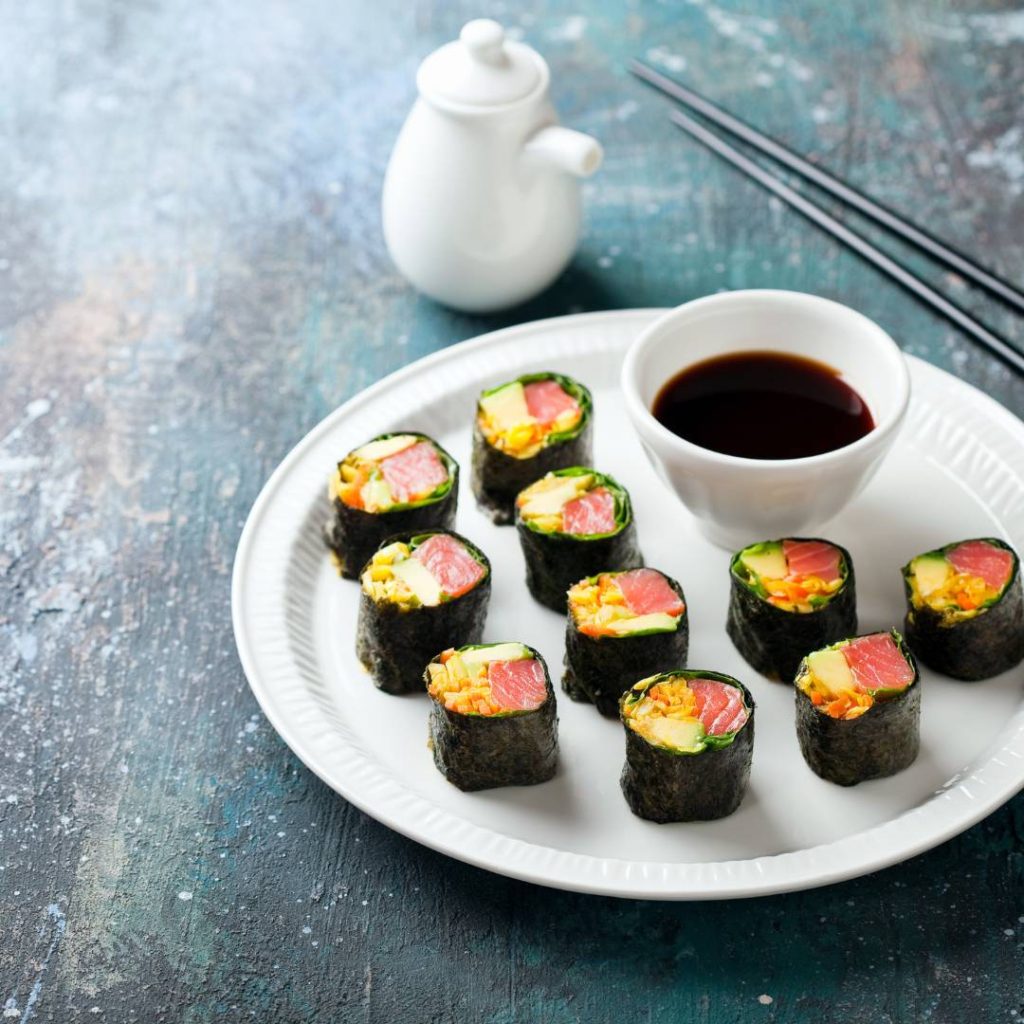 Japanese keto sushi rolls on a plate with chopsticks.