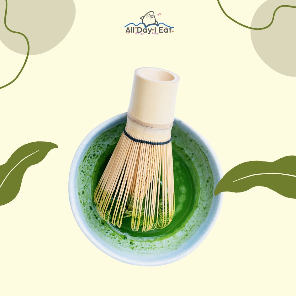 A bowl of matcha green tea with a bamboo whisk.