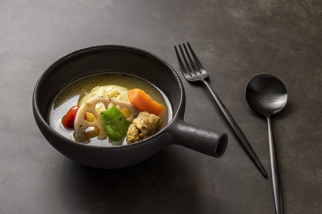 A Hokkaido-inspired bowl of soup with vegetables and a fork.