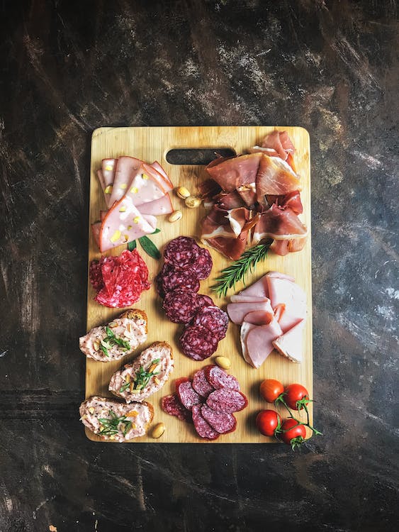 Hinoki Vs Maple Cutting Board featuring sliced meats on wooden chopping board