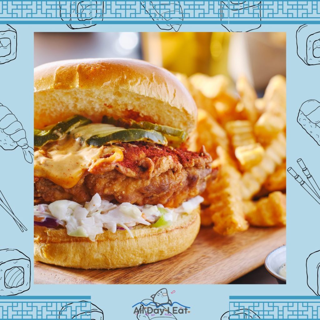 A picture of a chicken sandwich with fries on a cutting board.