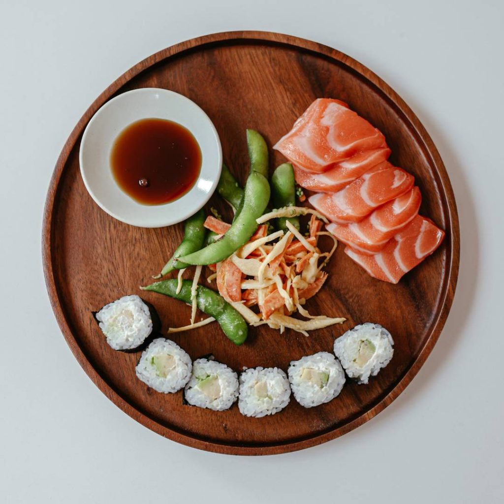 Japanese sushi and sashimi on a wooden plate.