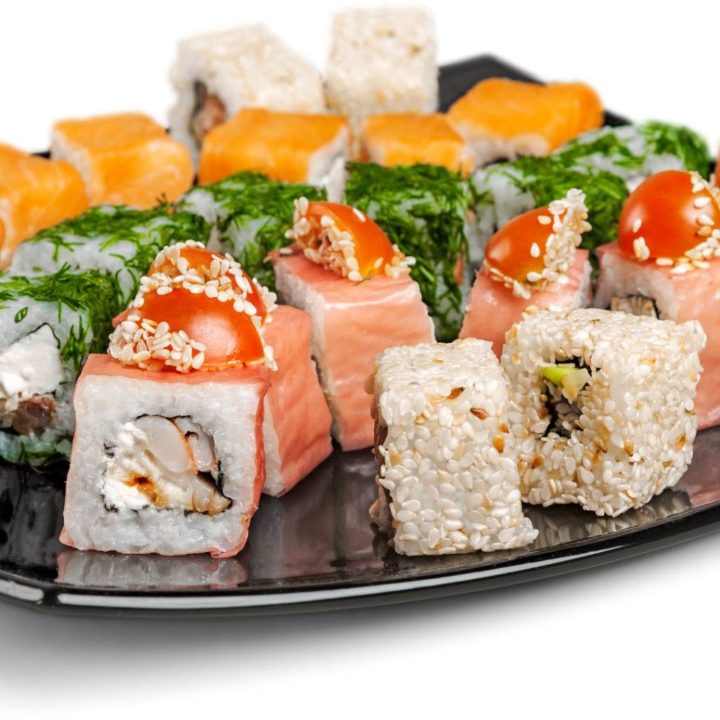 A plate full of sushi with sushi rice on a white background.