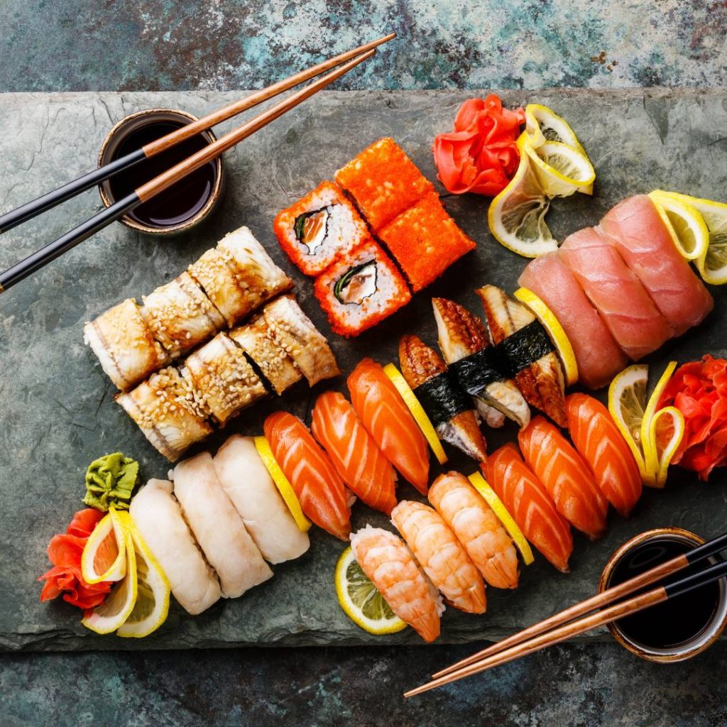 Japanese sushi on a slate table with chopsticks: Raw sushi.