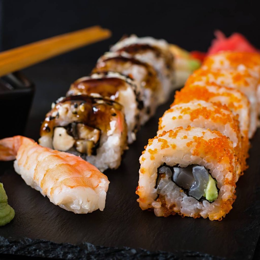 Japanese sushi served on a plate with chopsticks.