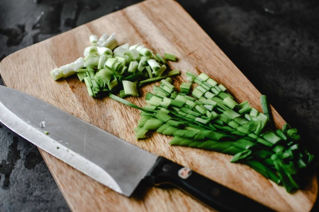 wood cutting board with knife and vegetable