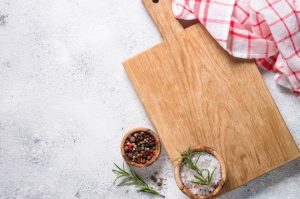 A strongest cutting board with herbs and spices on a white background.