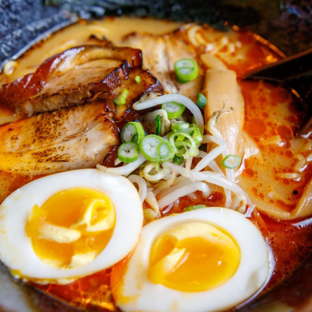 A Japanese dish featuring a bowl of ramen with an egg added.