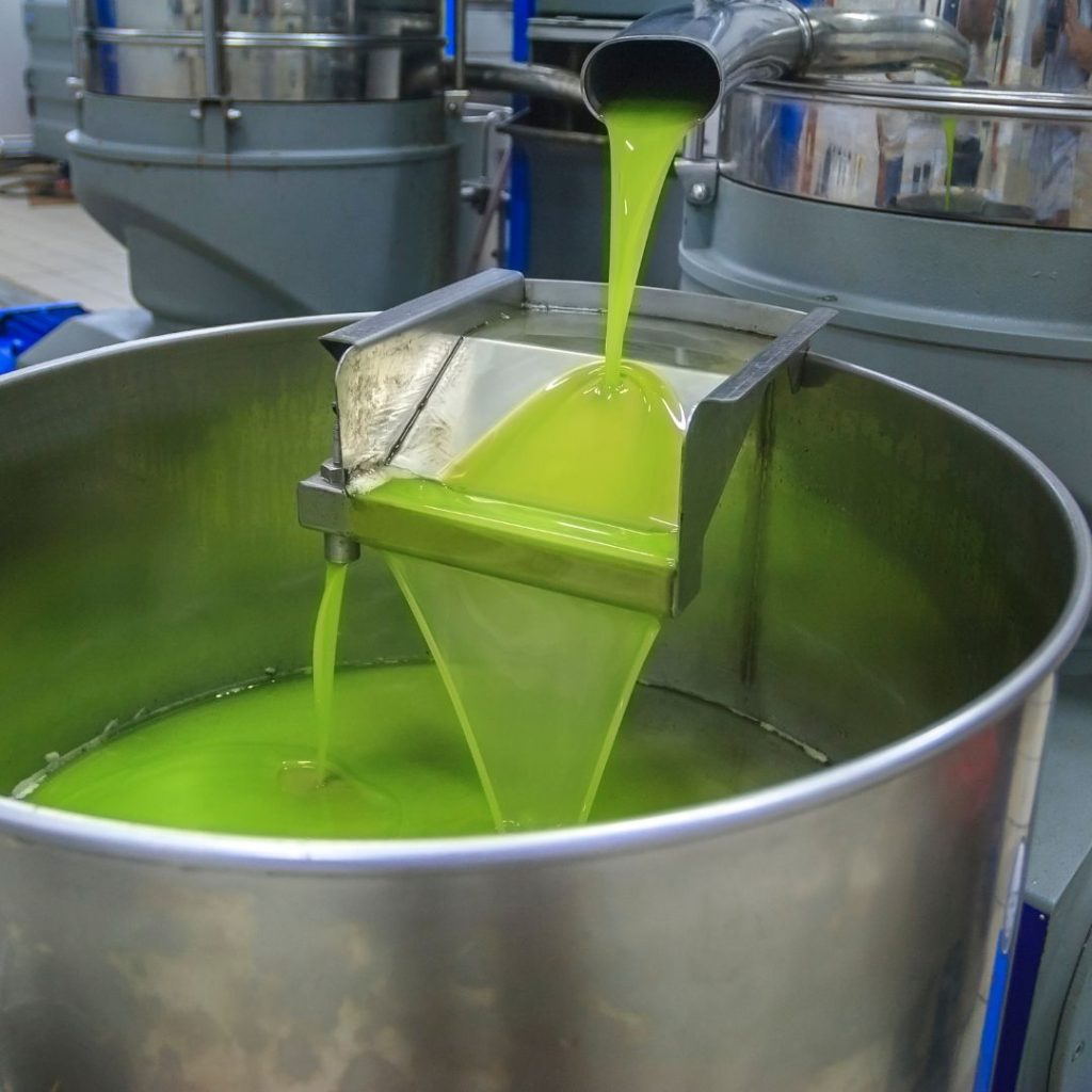 A factory machine pumps out olive juices.