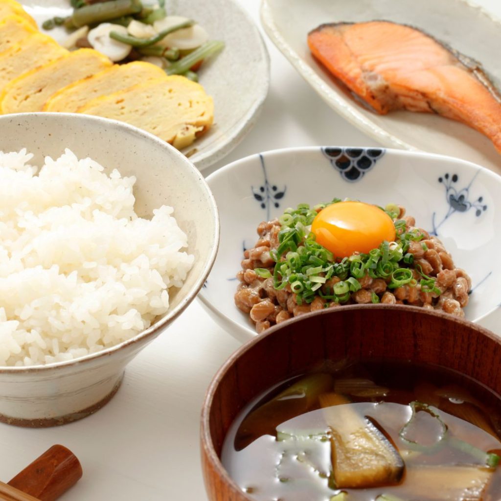 A full Japanese breakfast meal sits on a white table.