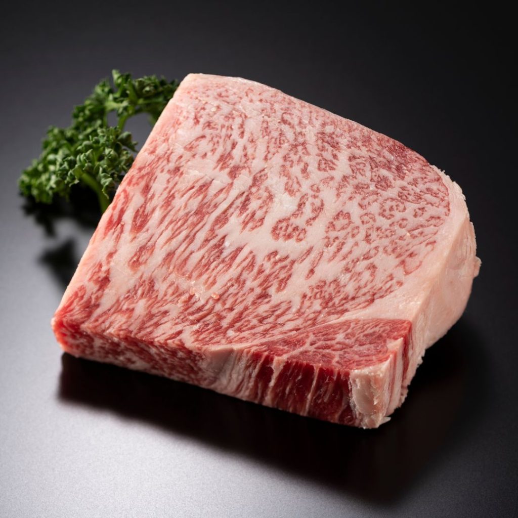 A piece of Wagyu beef rests on a black table.