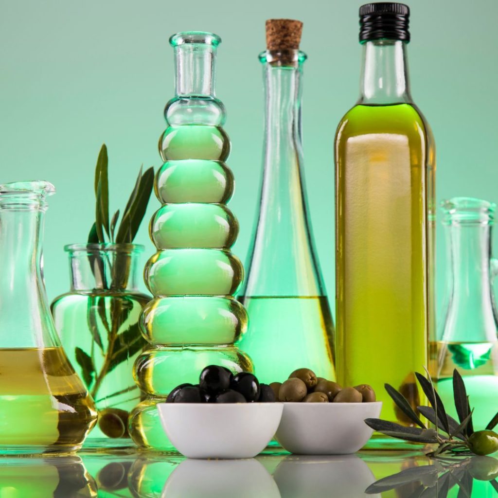 Bottles of olive oil and small containers of olives are displayed on a table