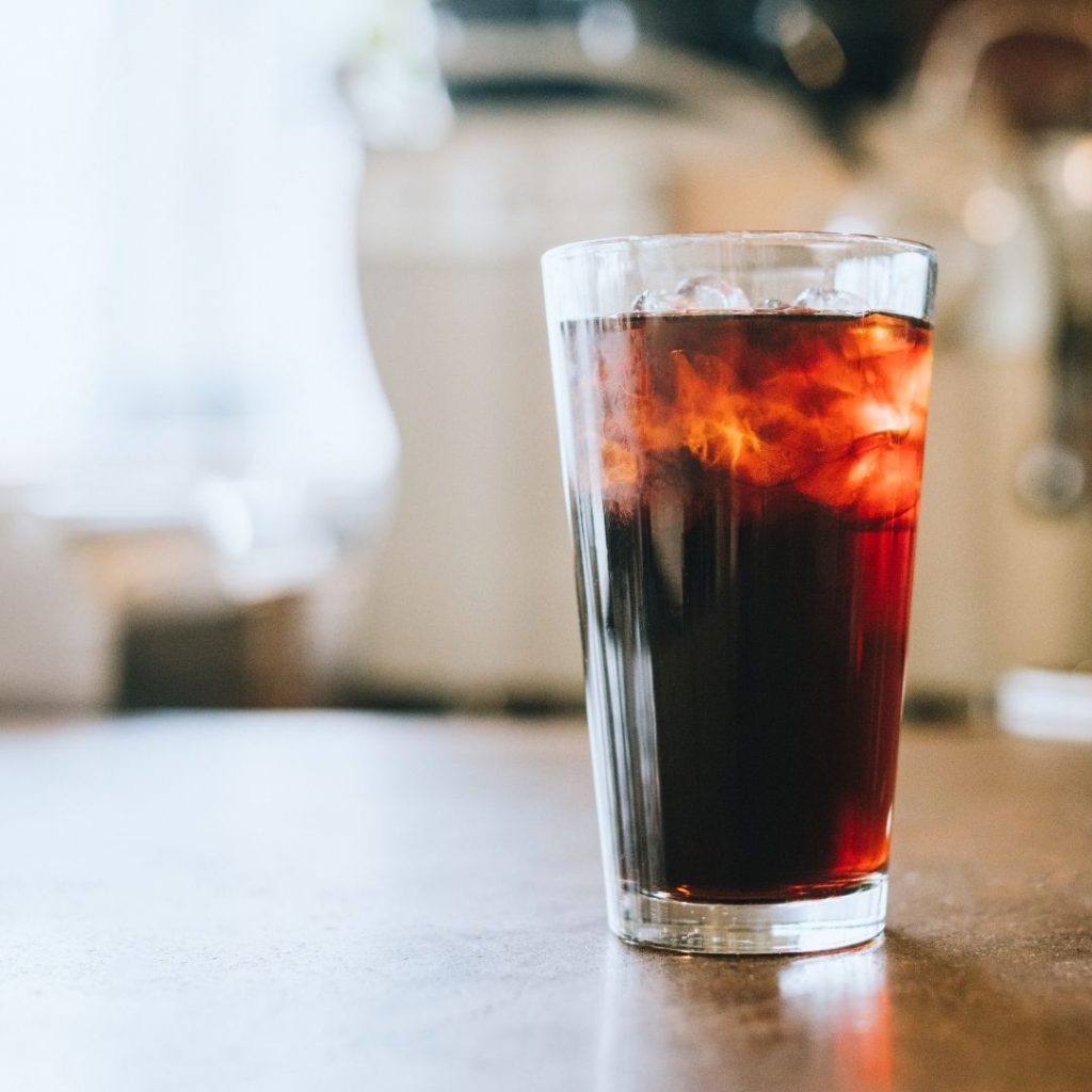 A glass of cold brew coffee sitting on a table.