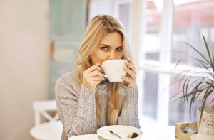 A woman enjoying a cup of coffee in a cafe.