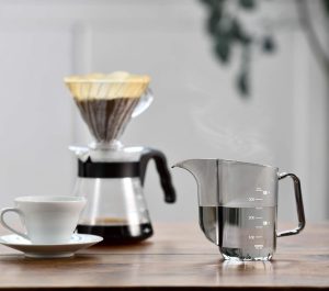 A Hario Air Kettle review with a coffee maker and a cup of coffee on a table.