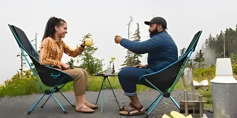 A man and a woman both sitting down on two folding chairs