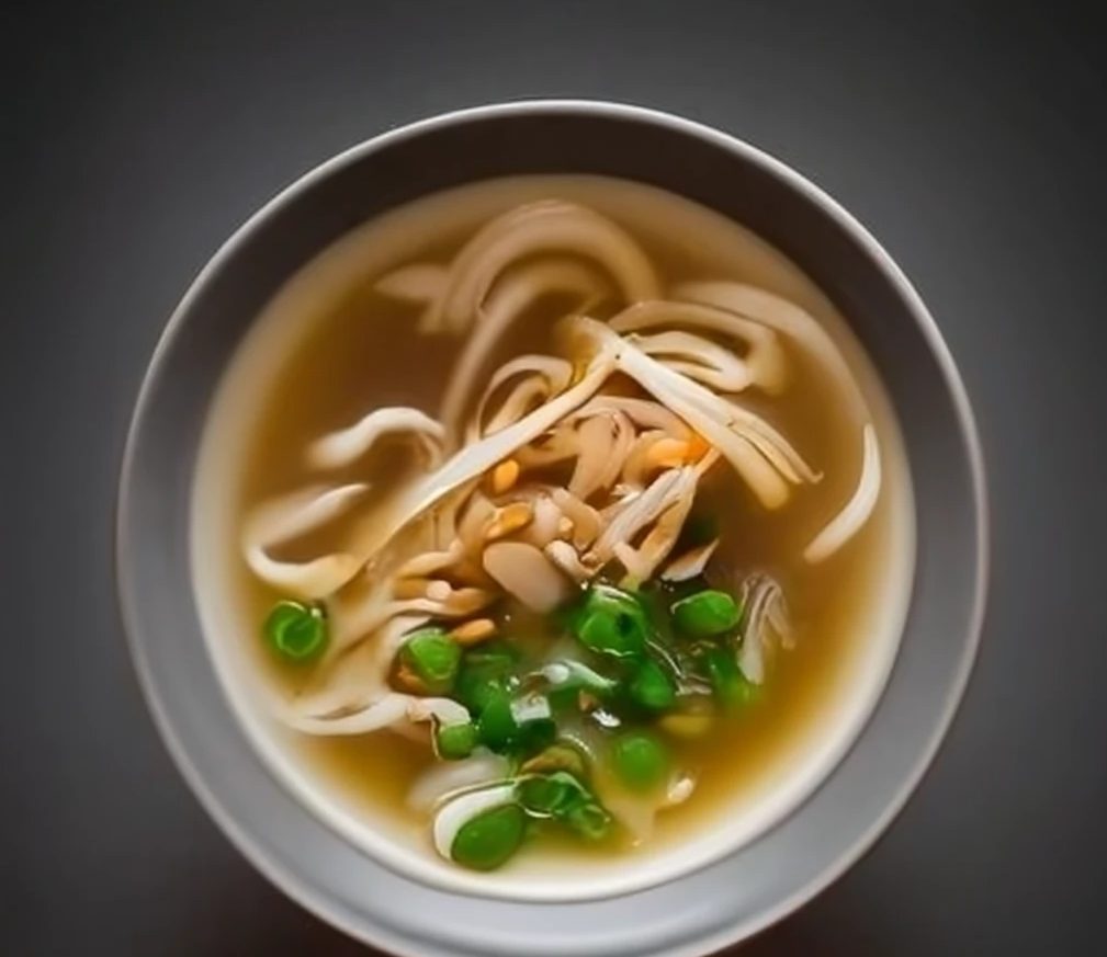 Miso soup with noodles and peas.