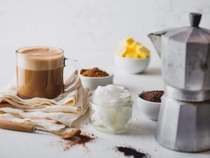 A cup of coffee and some ingredients, including Native Vanilla Bean Powder, on a table.