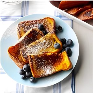 A plate of french toast with blueberries and powdered sugar.