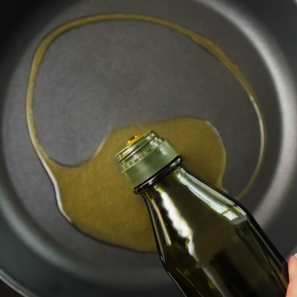 Olive oil gets poured in the cooking pan.