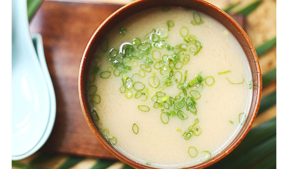 A bowl of soup with a spoon on top.