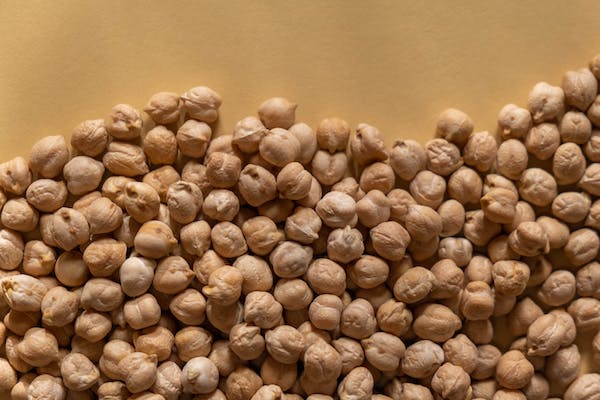 A pile of chickpeas on a yellow background, resembling miso soup.