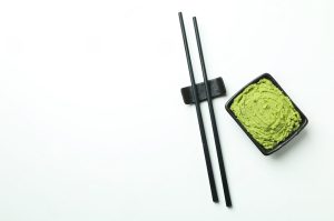 Wasabi powder and chopsticks on a white background.